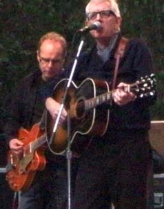 Nick Lowe sings and strums acoustic guitar. [Photo by Grace Sankey-Berman] 