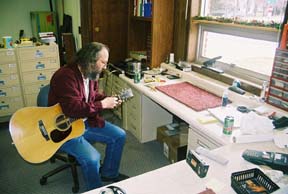 Bob Popek works on a guitar at his workbench, with plenty of natural light. [Photo by Tom Ineck]